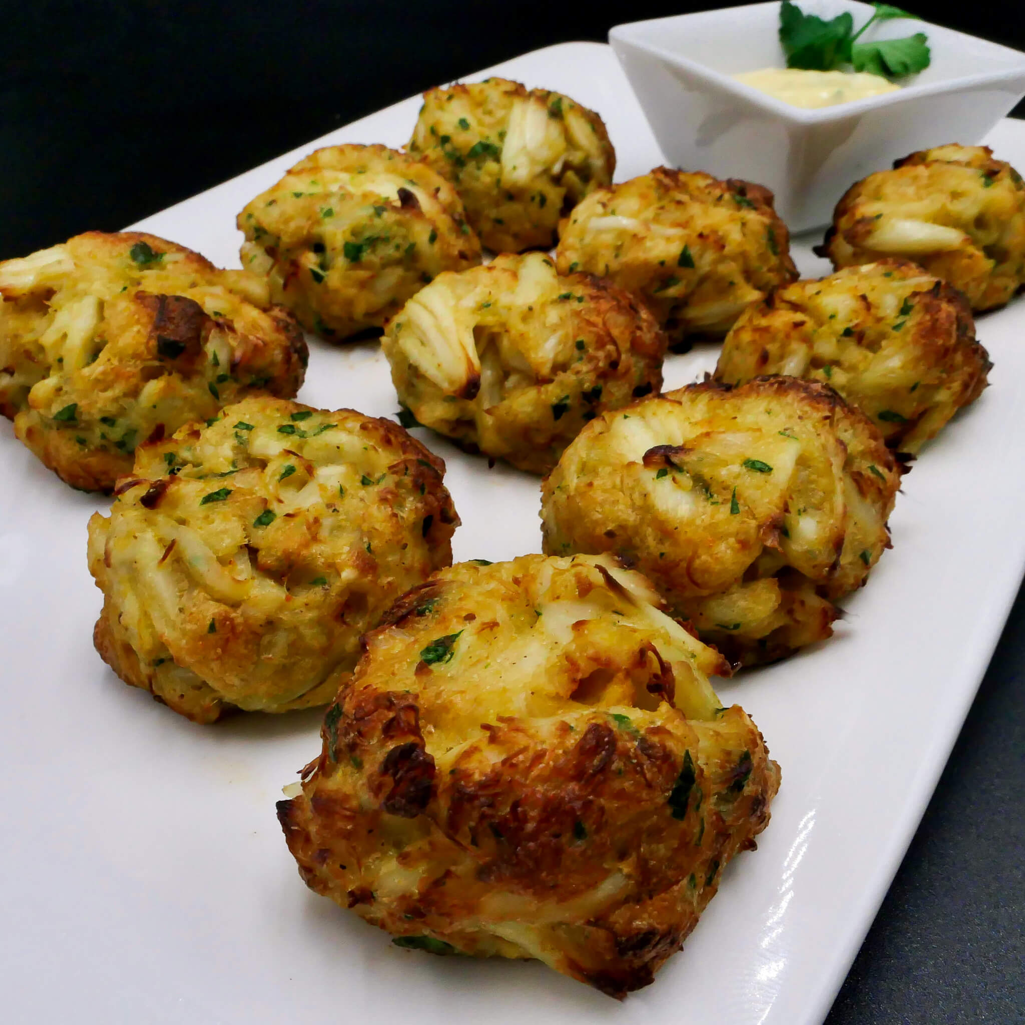 crab cake bites on a white plate with sauce